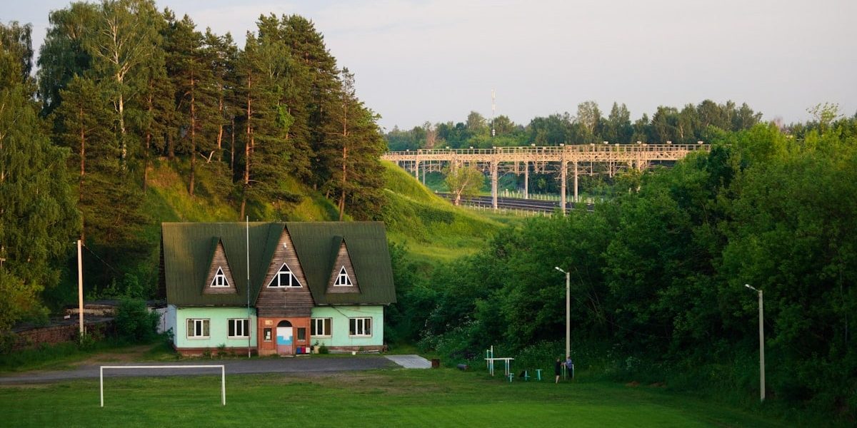 a green house with a soccer goal in front of it