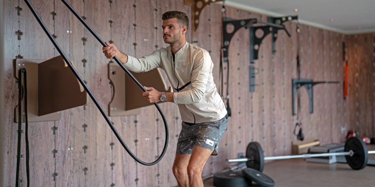 a man holding a gym rope in a gym